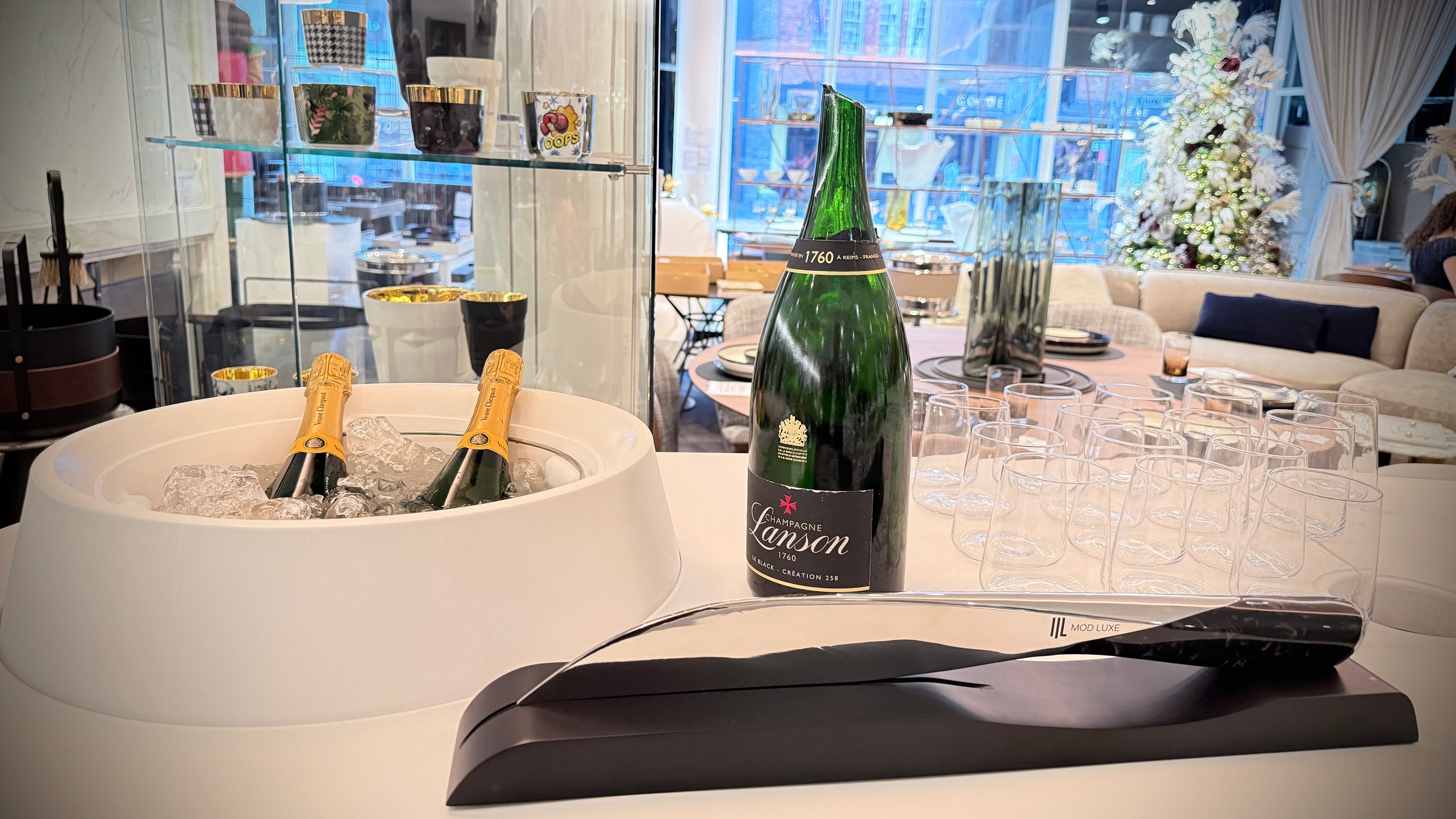 SPLENDOUR Champagne Sabre by MOD LUXE displayed with champagne bottles and glasses during a refined champagne service.