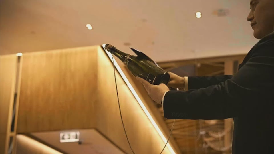 Sabrage masterclass video featuring a sommelier demonstrating how to use a chain for safety and environmental responsibility during a sabrage performance with the SPLENDOUR Champagne Sabre by MOD LUXE.